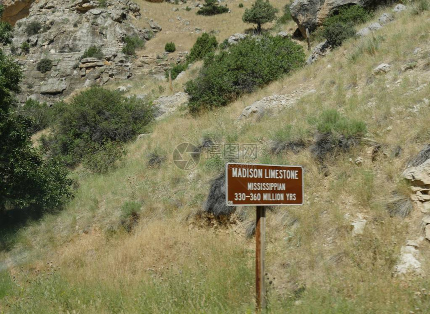 麦迪逊石灰岩路边的标志时间在3亿到36亿年前在怀俄明州穿过图片