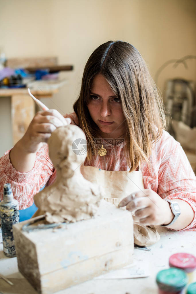在她工作室工作的女雕塑家Ceramis艺术家用天然粘土图片