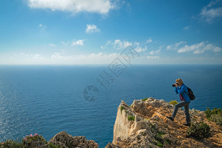 女游客站在悬崖边缘图片