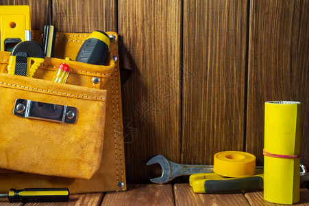 旧木制背景皮革袋中的工具和工具图片