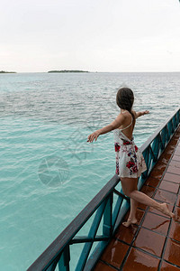 穿裙子的年轻女孩正站在一家海洋餐馆里图片
