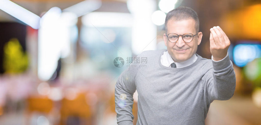 中年商务阿拉伯男子在孤立的背景下戴眼镜用手和指自信地表图片