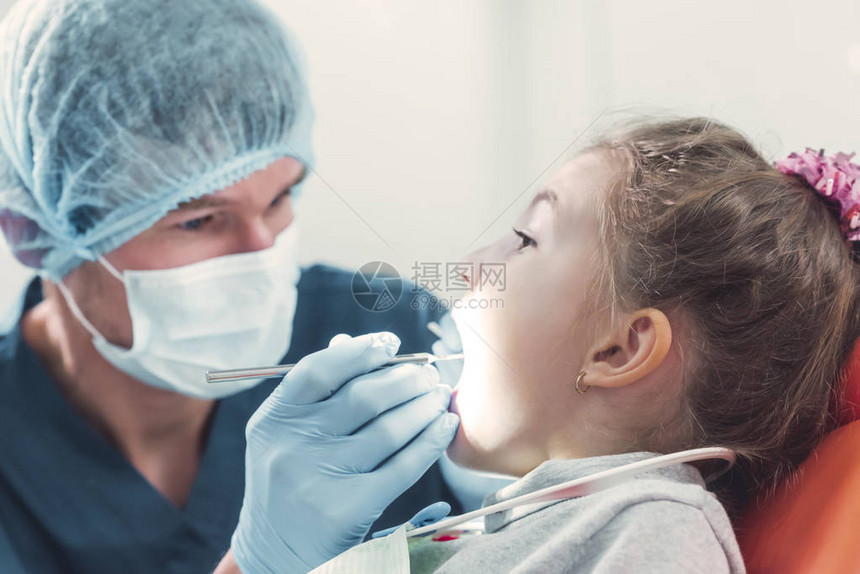 检查一个小孩牙齿的牙科医生蓝色活跃的牙医柜子口腔健康想法图片
