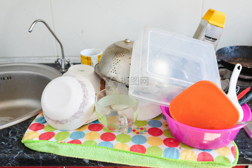 清洁的碗和厨房用具在厨房水槽附近的彩色毛巾上烘干图片