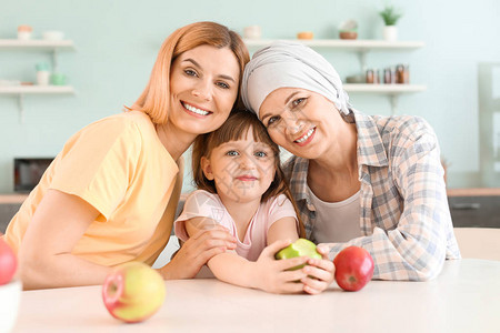 在家中厨房与家人一起接受化疗的女性图片