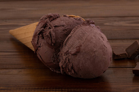 巧克力冰淇淋夹在华夫饼蛋卷里还有木制背图片