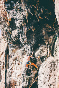 在自然地形上攀岩一个人爬上岩石登山训练克图片