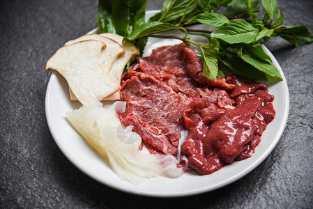 白盘上的肉食牛肉切片肝脏和蘑菇蔬菜图片