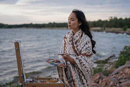 亚洲女艺术家在画布上绘画图片