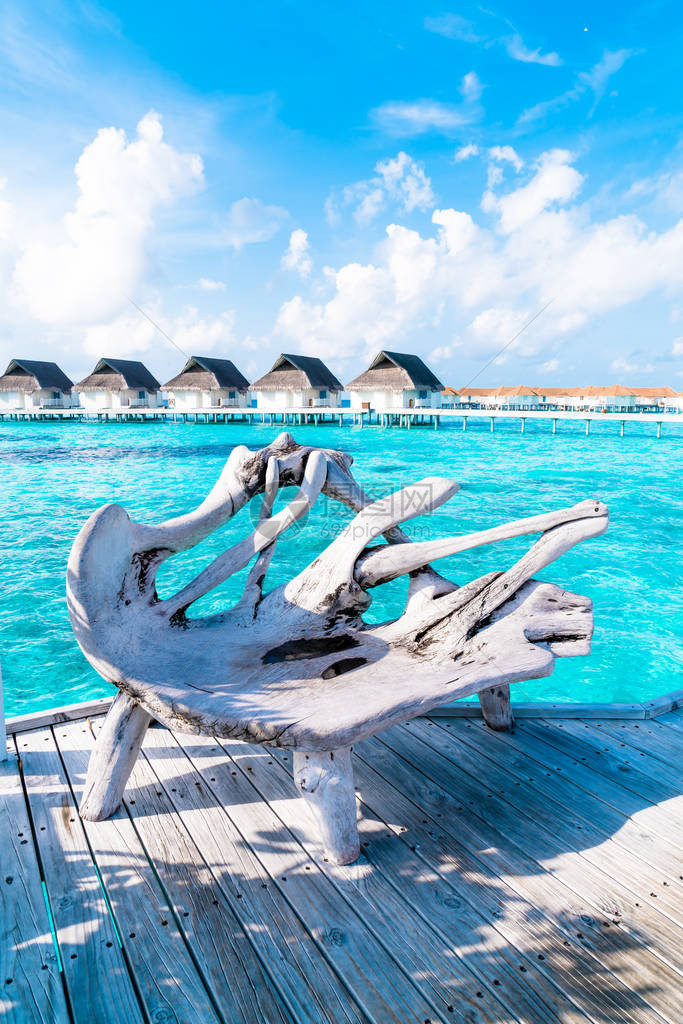 带有热带马尔代夫度假酒店和岛屿的木长凳图片