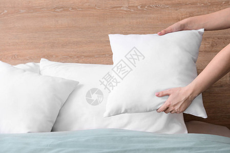 女人在床上蓬松柔软的枕头图片