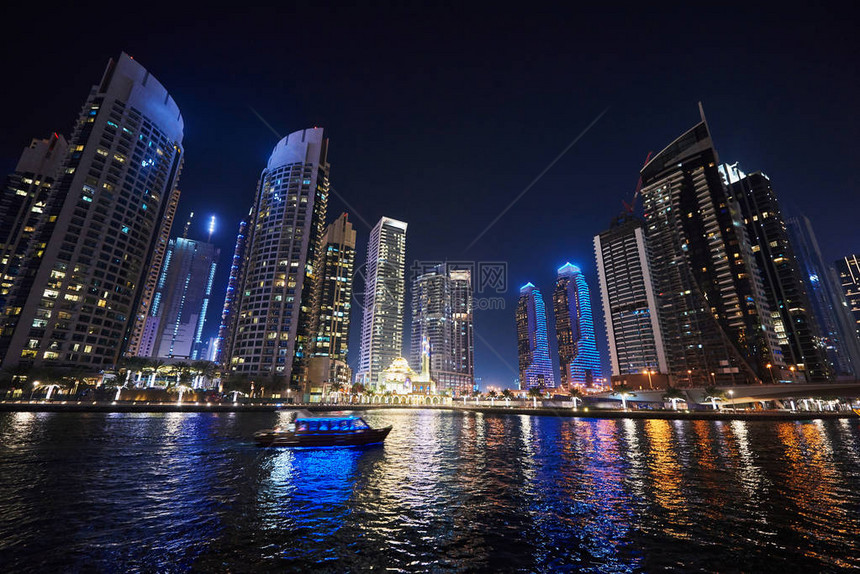 夜里迪拜Marina与多彩的旅游船在水上游荡图片