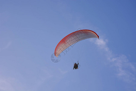 Paramotor有权力的滑翔伞与红色白降落伞在空中飞图片