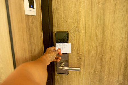男子在旅馆房间使用钥匙卡进入数字门系统图片