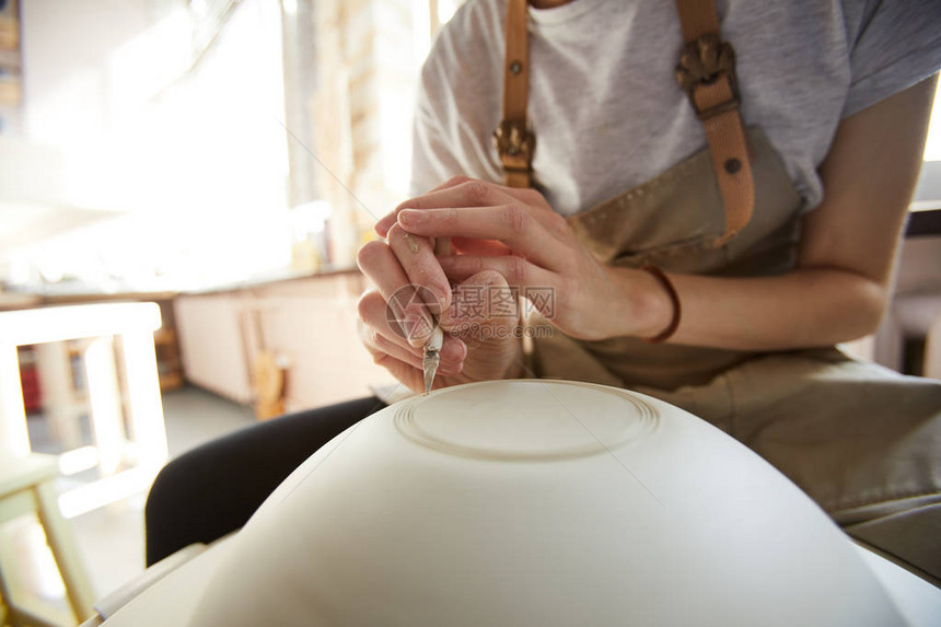无法辨认的女工匠在陶瓷手推车上手工装碗复制空间的图片