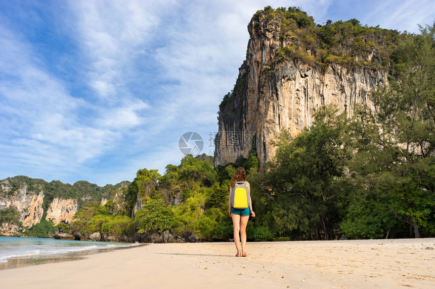 一名女游客背着包站在泰国的拉莱海滩上图片