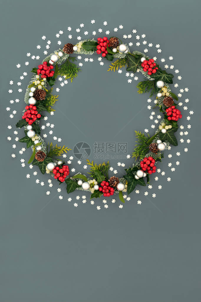 圣诞花环装饰有装饰雪花冬青浆果槲寄生云杉冷松果和灰色背景上的银球小玩意节图片