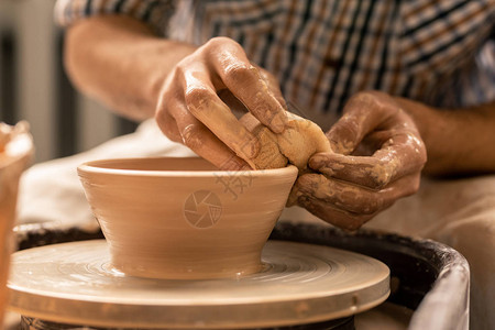 陶匠的手在用轮式陶器轮子工作时图片