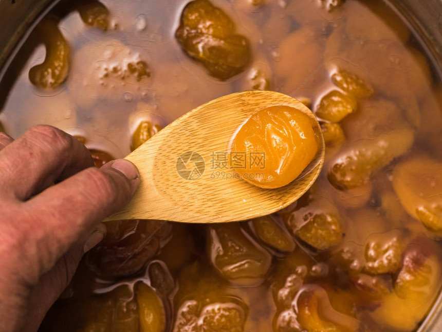 在果酱背景上用木勺煮了杏仁准备苹图片