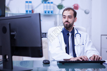 在医院的柜子里用他的电脑工作的医生的画像医生图片