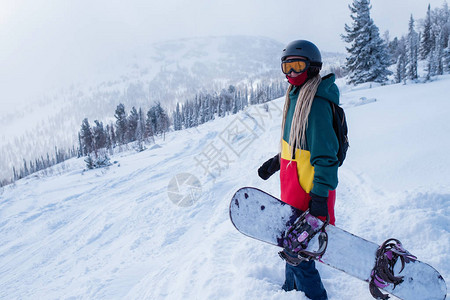 滑雪板女人在山上的雪坡上图片