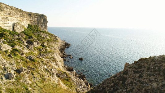 爱尔兰海洋陡峭漂浮的景象清晰可见平静水附近的绿色斜坡和清蓝天空背景图片