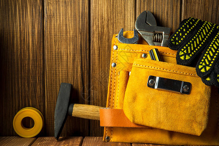 皮革袋中的工具和工具在旧木制图片