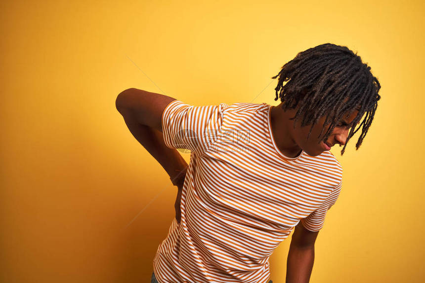 身穿脱条纹T恤的非洲男子在孤立的黄色背景上站立图片