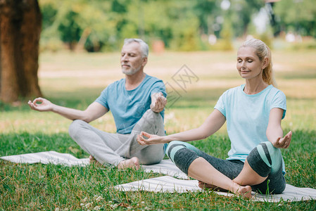 成年男女坐在瑜伽垫子上时在莲花图片