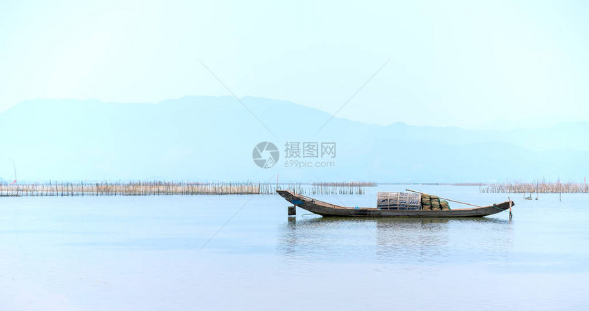 孤零的木制渔船在泻湖上出海作为人们在茫大海中美图片