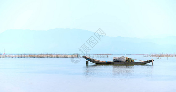 孤零的木制渔船在泻湖上出海作为人们在茫大海中美背景图片