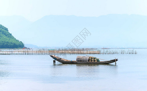孤零的木制渔船在泻湖上出海作为人们在茫大海中美背景图片