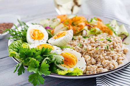 早餐碗加燕麦生菜胡萝卜和煮鸡蛋新鲜沙拉健康食品图片