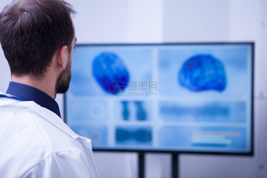 年轻男医生在手术后检查他的脑部图片