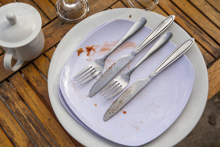 餐后肮脏的盘子用叉子刀和叉子将空盘图片