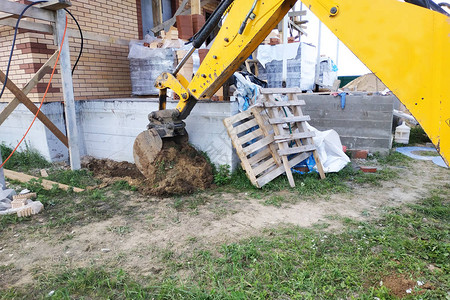 挖土机在正建造的建筑物周围挖掘飞镖图片