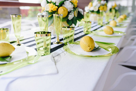 用盘子上的整个柠檬和条纹桌布装饰的宴会桌图片