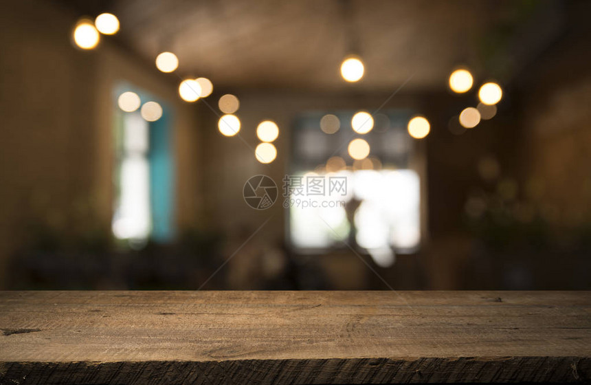 深色背景下咖啡馆餐厅模糊浅金色散景上的空木桌面图片