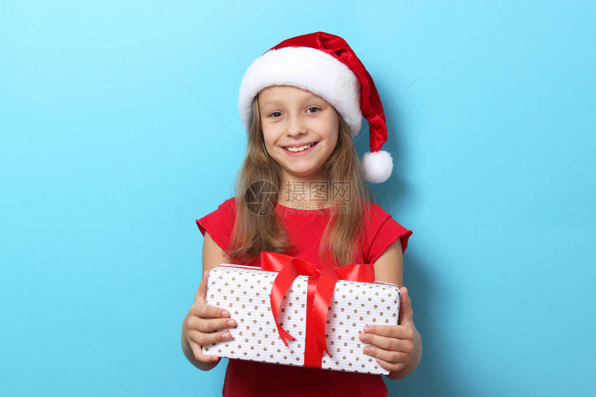 穿着圣诞帽子的可爱快乐女孩带着彩色背图片