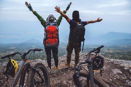 亚洲夫妇女人和男人旅行自然旅行放松在野外骑自行车荒野站在岩石图片