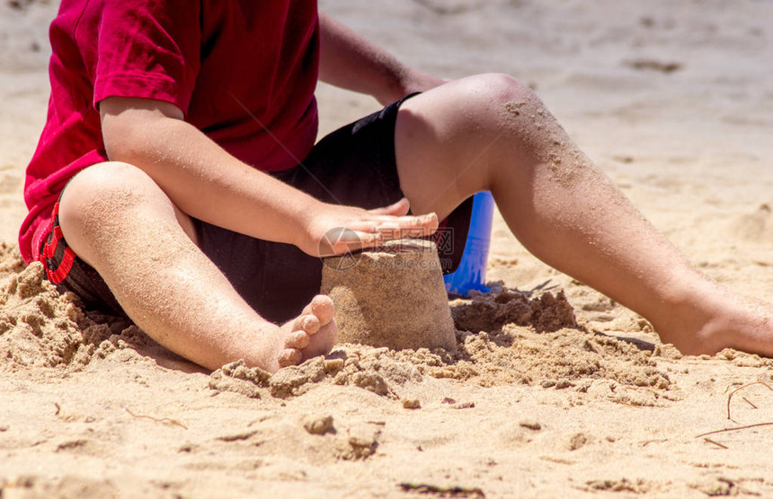小手和赤脚的趾在沙地上玩耍图片