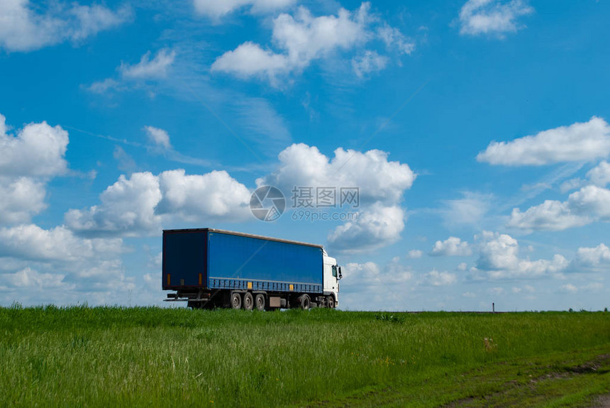 乡下路上的大蓝色大卡车在阳光日送图片
