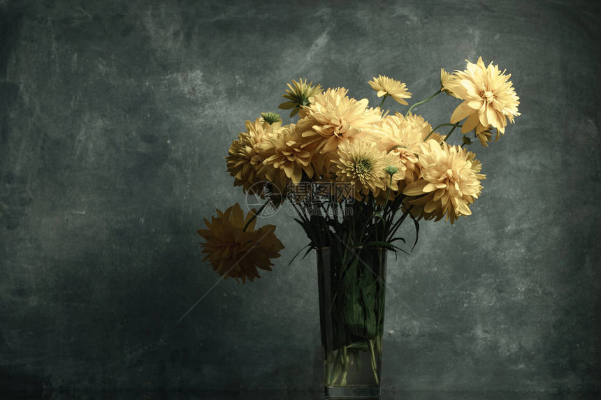 黑色玻璃桌上的花瓶里的黄色花朵美丽的图片