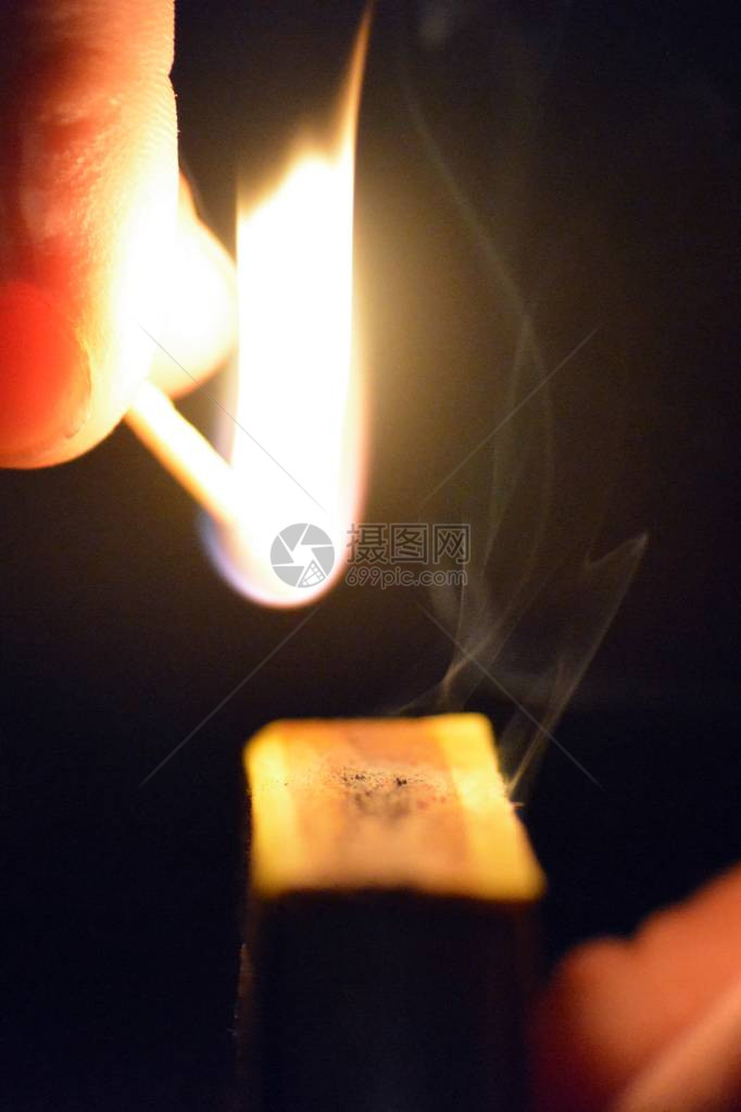 在火柴盒上的黑暗中点燃火柴夜间照明火柴的特写镜头火图片