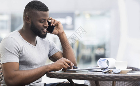 成功的非洲美国商人通过手机全景复制空间等电话咨询他的工人图片