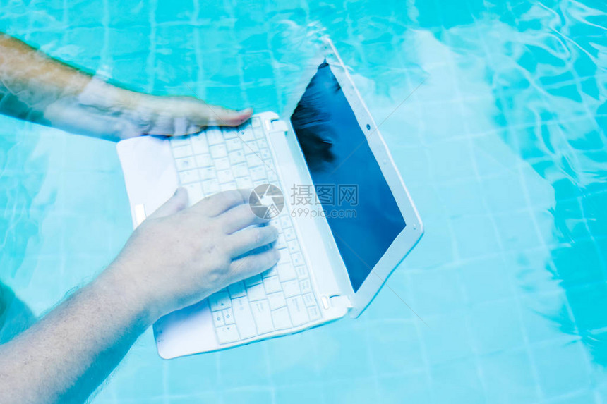 使用笔记本电脑在水下工作的男手妨碍工作的概念模图片