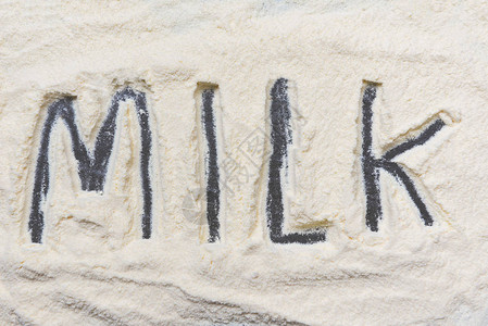 深色背景中的奶粉奶粉文本顶视图蛋白质或概念的图片