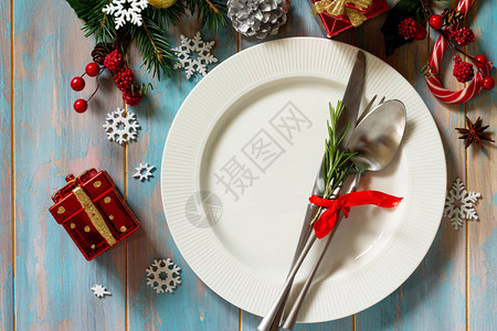 圣诞节背景圣诞装饰桌节日白盘子和餐具与复古木桌上的圣诞装饰图片