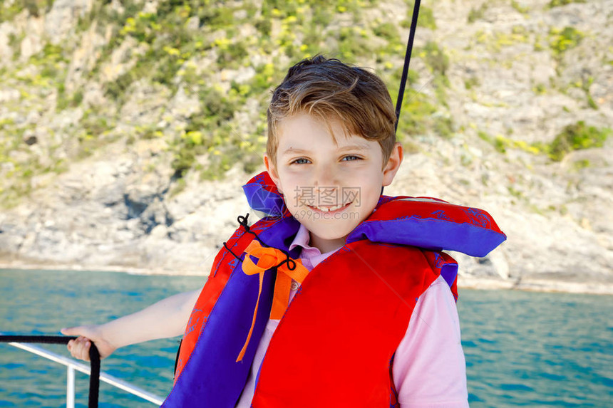 快乐的金发小男孩享受帆船之旅阳光明媚的日子在海洋或海上的家庭度假健康美丽的学童在游艇上微笑和玩乐与村庄和图片