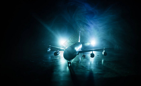 艺术品装饰白色客机准备从机场跑道起飞夜间飞机的剪影图片